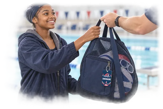 A swimmer receiving a mesh gear bag with a South Pier swimming tag near the pool deck